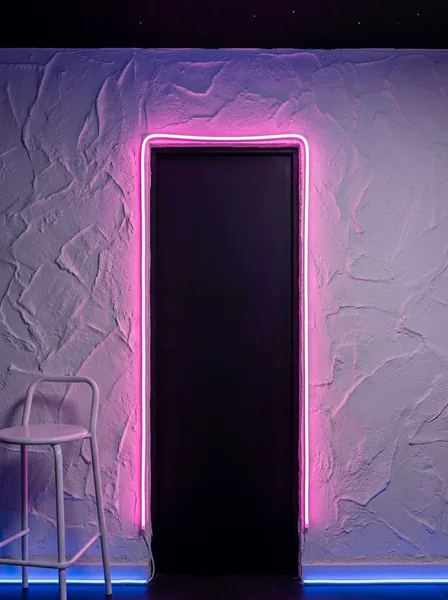 Pared de estuco blanco con una puerta oscura enmarcada por un neón rosa.